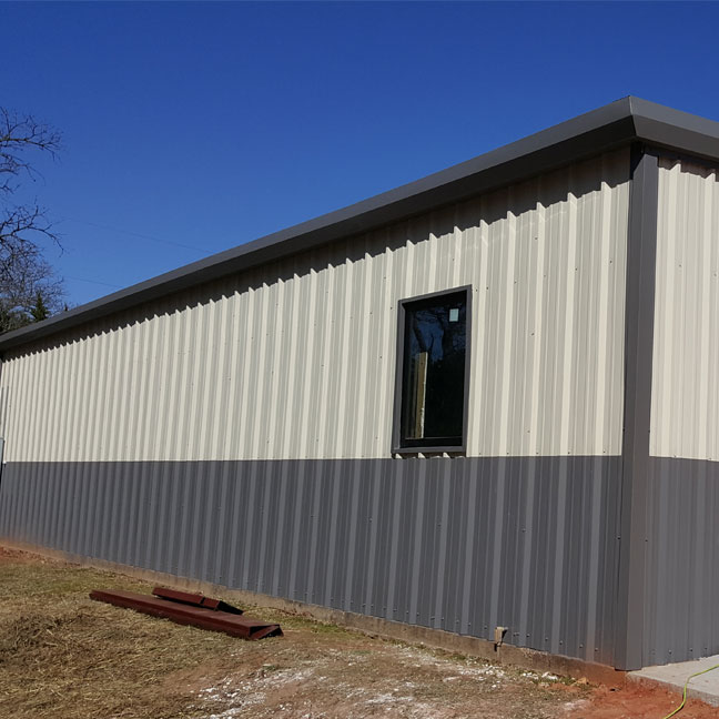 Metal shop building in Oklahoma City. Old perimeter trim removed and new gutter and trim installed.